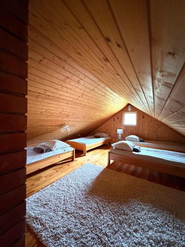 a room with two beds in a wooden cabin at Männiliiva Holiday Home with Sauna in Hiiumaa