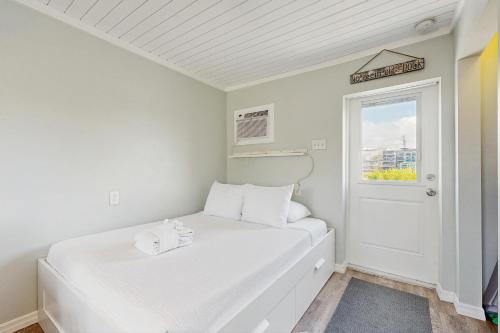 a white room with two beds and a window at CK03a Fisherman's Bungalow in Conch Key