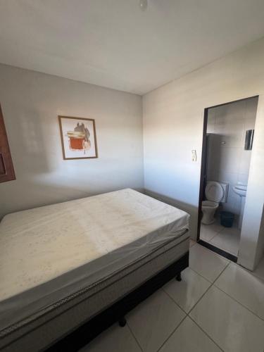 a small bedroom with a bed and a toilet at Flat Alicia mar in Tamandaré