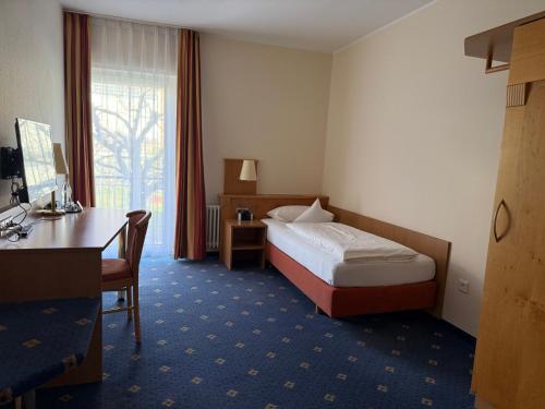ein Hotelzimmer mit Bett und Schreibtisch in der Unterkunft Hotel Altenberg in Baden-Baden