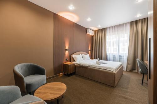 a hotel room with a bed and a chair at MIRAFI Hotel in Almaty