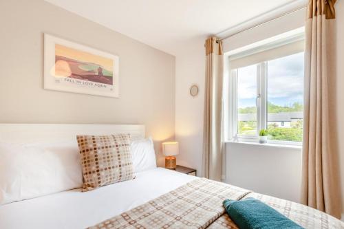 a bedroom with a white bed and a window at 3 Bed in Tenby oc-93359 in Redberth