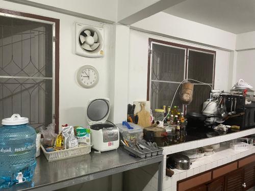 a kitchen with a counter top with a clock on the wall at Southeast Asia Activist House in Bangkok