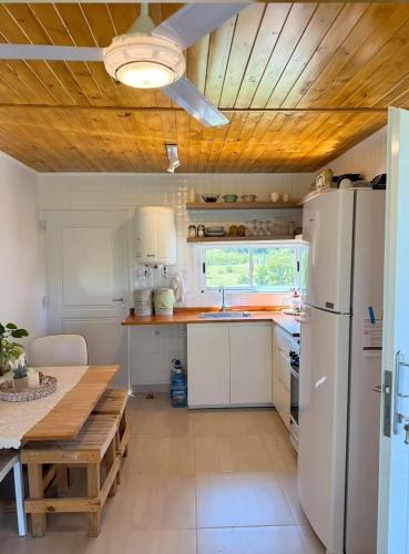 a kitchen with a white refrigerator and a wooden ceiling at Casa de campo ElChale cerca del autodromo de Rafaela in Rafaela