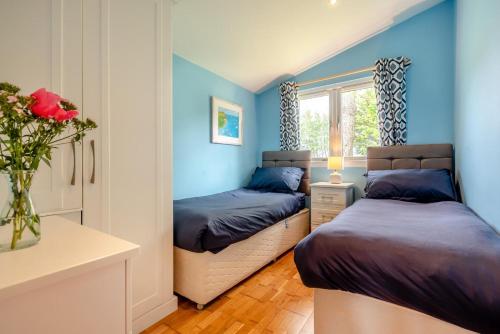 two beds in a room with blue walls at 2 Bed in St. Merryn oc-p00883 in Saint Merryn