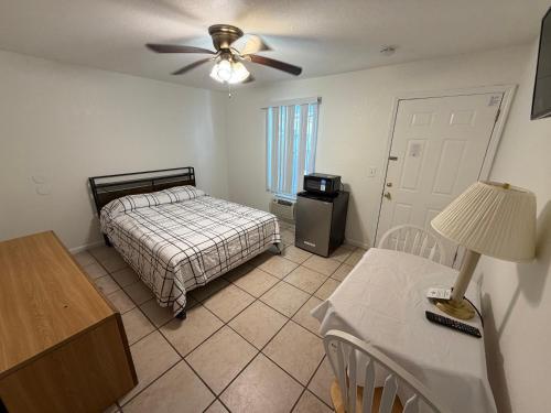 a bedroom with a bed and a table and a ceiling fan at Sunrise Motel in Seaside Heights
