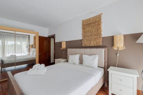 a bedroom with a large white bed and a window at Serenity Troia, By Home Match in Troia