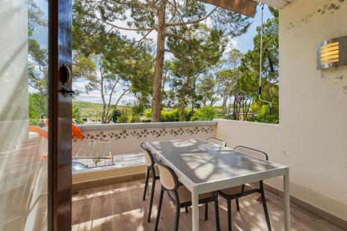 a table and chairs on a balcony with a window at Serenity Troia, By Home Match in Troia