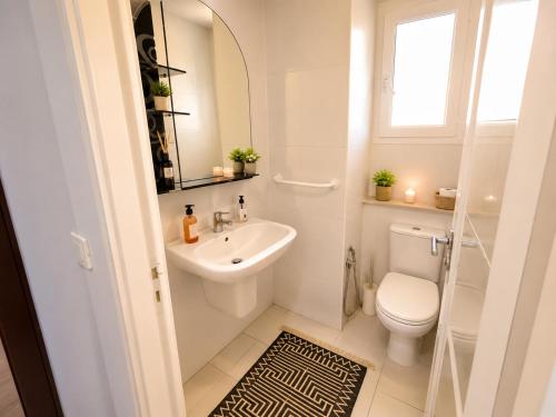 a bathroom with a sink and a toilet and a mirror at Cozy Stay appartement in Sukrah