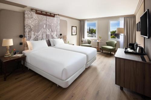 ein großes weißes Bett in einem Hotelzimmer in der Unterkunft NH Brugge in Brügge