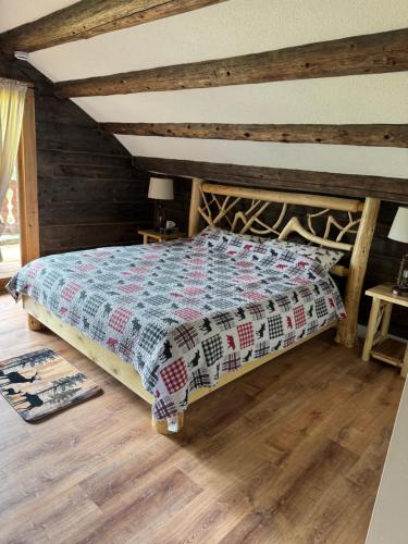 a bedroom with a bed with a quilt on it at Nakiska Bear Ranch in Clearwater