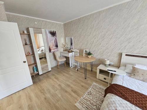 a bedroom with a bed and a table and a desk at Апартаменти Aura Bliss in Zhytomyr