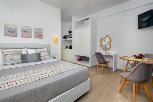 a bedroom with a bed and a table and chairs at Sunshine Medousa Suite in Glifades