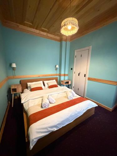 a bedroom with two beds and a chandelier at Mirello House Otel Tuzla in Tuzla