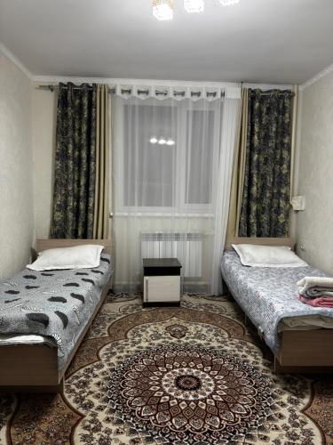 a bedroom with two beds and a rug at East guest house in Tegermenti