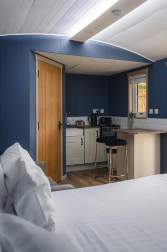 a room with a bed and a kitchen with blue walls at The Bannville Hotel in Banbridge