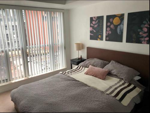 a bedroom with a bed and a large window at Downtown Toronto Condo in Toronto