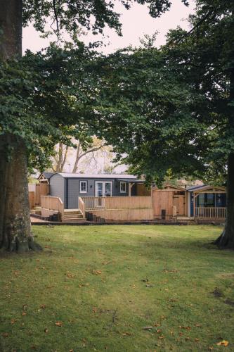 a house in a field with a fence and a tree at The Bannville Hotel in Banbridge
