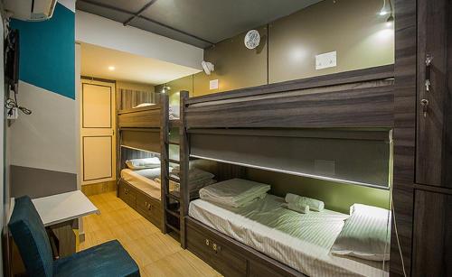 two bunk beds in a room with a desk and a chair at Pod N Beyond Smart Hotel in Jamshedpur