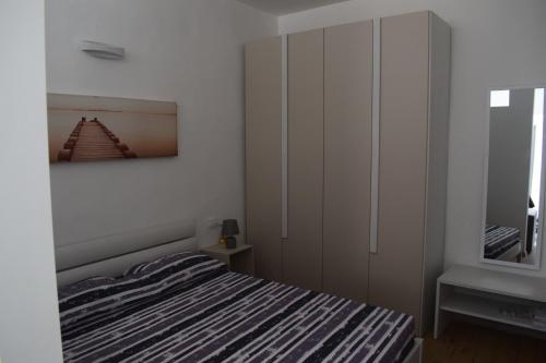 a bedroom with a bed and a dresser and a mirror at Il Flat Arona Centro, Le Dimore del Corso in Arona