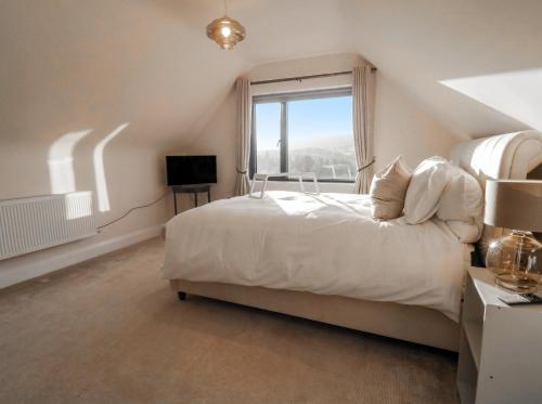 a bedroom with a white bed and a window at Hanowen House in Dungloe