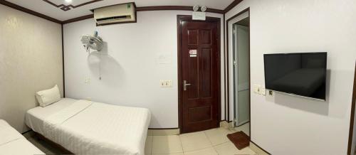 a room with a bed and a flat screen tv at Anh Duong Hotel in Noi Bai