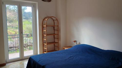 a bedroom with a blue bed and a book shelf at Domus amica 1 in Finocchito