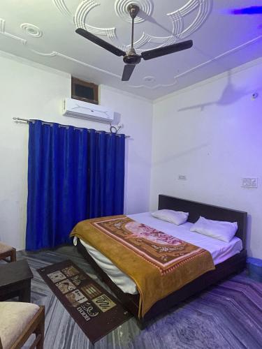 a bedroom with a bed with a blue curtain at Hotel glass house in Kāta Patthar