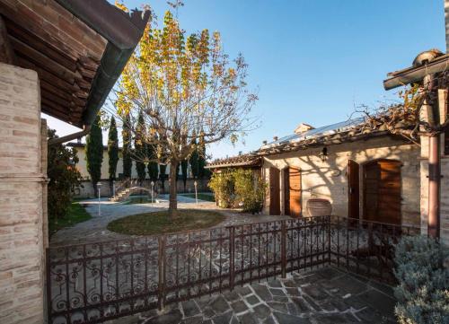 una recinzione di fronte a una casa con un albero di Residenza D'epoca Il Biribino a Città di Castello