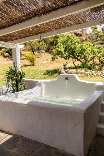 a bath tub sitting under a pergola at Finca Santa Teresa, Casa La Higuera in Casares