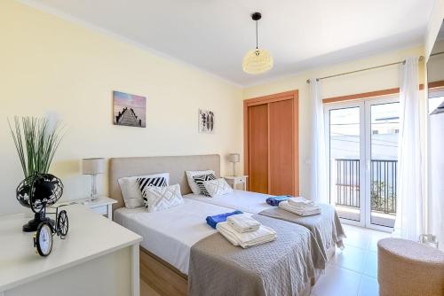 a bedroom with two beds and a window at Olive Tree penthouse in Tavira