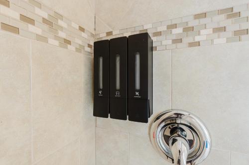 a bathroom with a black soap dispenser on the wall at Florida Paradyse 10MIN DOWNTOWN Y 10 MIN BEACH in Fort Myers
