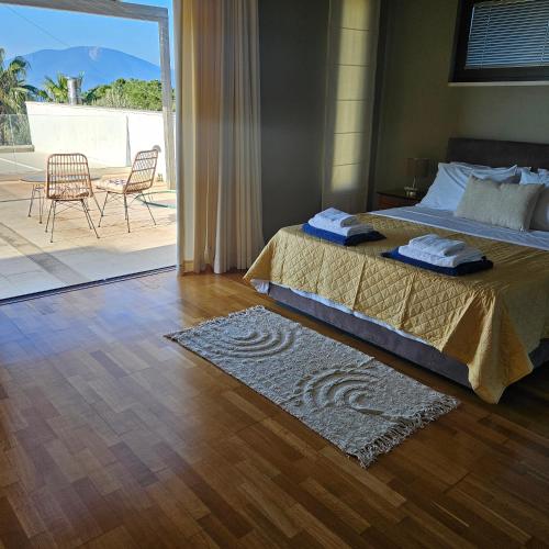 a bedroom with a bed and a view of a patio at Evia Palm Beach Villa in Politika