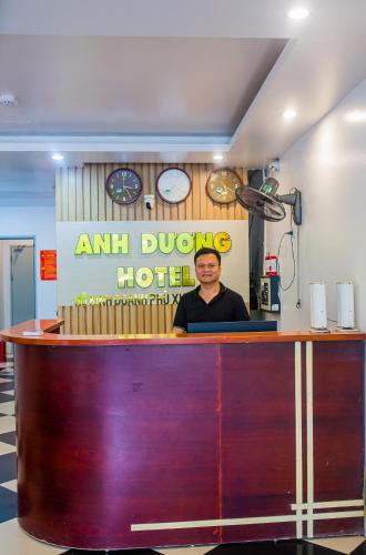 a man standing behind a counter in a room at Anh Duong Hotel in Noi Bai