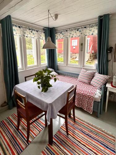 a room with a table and a bed and a table and chairs at Savikulma savihuone B&B in Mynämäki