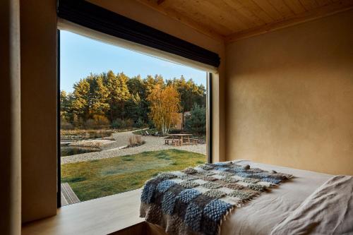 a bedroom with a large window looking out at a yard at РІЗНОтрав'я in Solygy