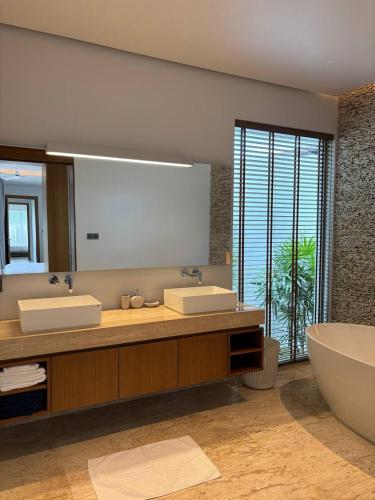 a bathroom with two sinks and a large mirror at Lucky Eight Villa in Ban Phru Champa