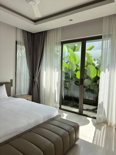 a bedroom with a bed and a large window at Lucky Eight Villa in Ban Phru Champa