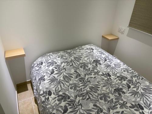 a bedroom with a bed with a black and white blanket at Appartement 4 personnes in Sainte-Maxime