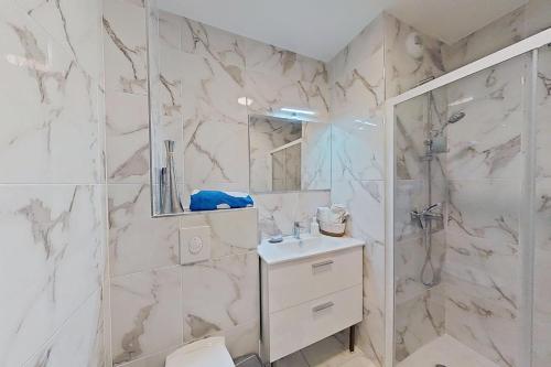 a white bathroom with a shower and a sink at Appartement Elégant & Raffiné in Noisy-le-Grand