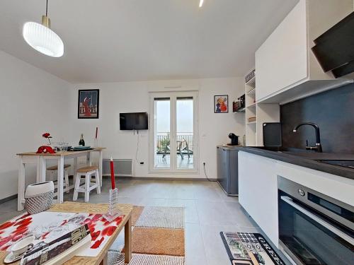 a kitchen with a table and a dining room at Appartement Elégant & Raffiné in Noisy-le-Grand