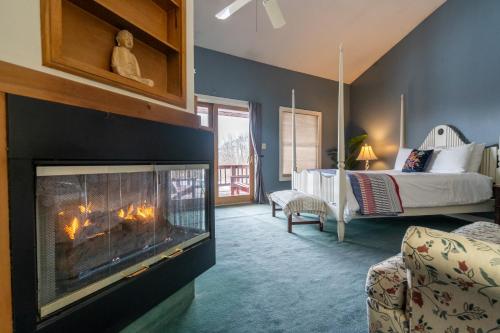 a living room with a fireplace and a bedroom at Point Au Roche Lodge in Plattsburgh