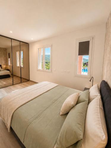 a bedroom with a large bed and two windows at Lake View Apartament 1 - Free Parking & Terrace in Cadegliano Viconago