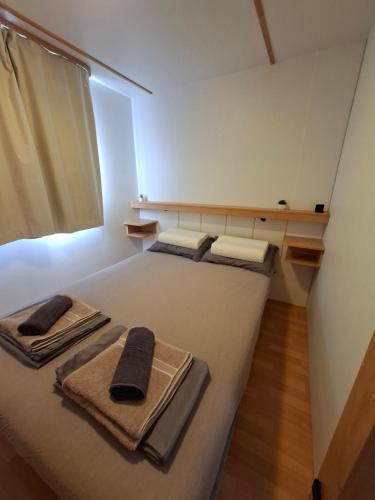 a bedroom with a large bed with towels on it at Mobile home Magdalena in Pirovac