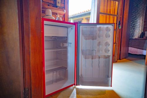 a red refrigerator with its door open in a room at Pousada Alto Pirapitinga in Resende