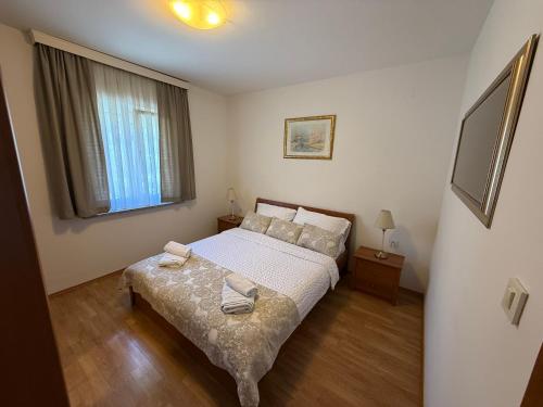 a small bedroom with a bed and a window at Apartments Palić in Baška