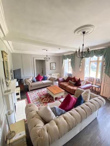 a large living room with a couch and a table at Russell Hill Manor in Peterborough