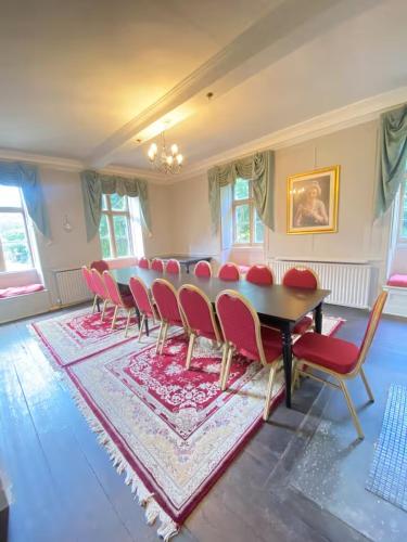 a dining room with a table and red chairs at Russell Hill Manor in Peterborough