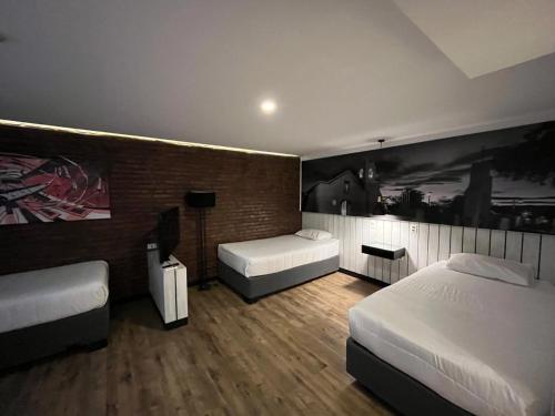 a bedroom with two beds and a painting on the wall at Hostal Boutique Black Cat in Santiago