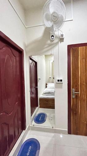 a room with a bed and a door and a fan at Seven Miles Hotel in Āīzawl